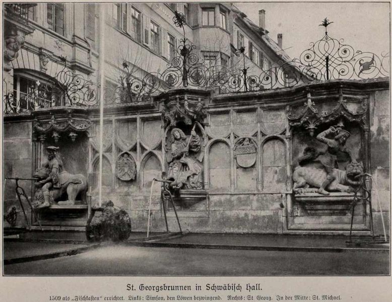 018 St. Georgsbrunnen in Schwäbisch Hall. 1509 als „Fischkasten“ errichtet. Links: Simson, den Löwen bezwingend. Rechts: St. Georg. In der Mitte: St. Michael.
