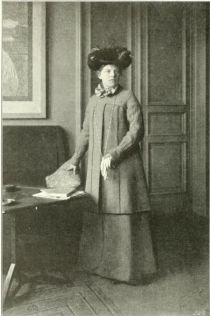 Frau Prof. van de Velde in einem von Herrn Henry van de Velde entworfenem Straßen-Kleide – Weimar